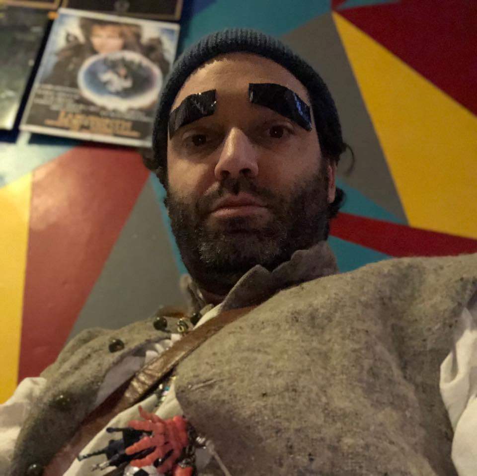 Louie Christie dressed as Labyrinth's Hoggle with old worldy fantasy clothes and a string of key-rings around his neck.